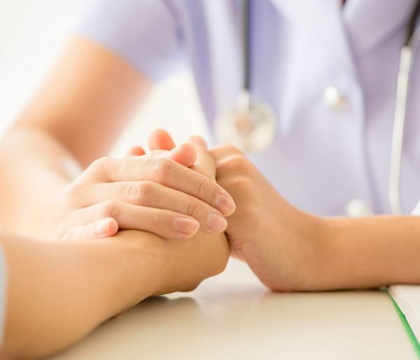 female psychologist consulting patient at the desk in hospital.